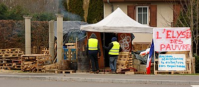 Installations de gilets jaunes sur un bord de route.