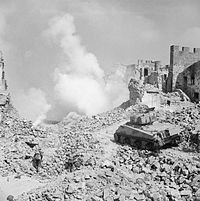 A Sherman tank of 19th Armoured Regiment, 4th New Zealand Armoured Brigade supporting infantry of 6th NZ Infantry Brigade, in a reconstruction of the action at Cassino, Italy, 8 April 1944. A Sherman tank of 19th Armoured Regiment, 4th New Zealand Armoured Brigade supporting infantry of 6th NZ Infantry Brigade, during a reconstruction of the action at Cassino, Italy, 8 April 1944. NA13800.jpg