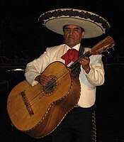 Hráč na mexický guitarrón v typickém oblečení mariachi