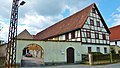 Bauernhof mit Wohnstallhaus (Fachwerk, verbrettert), Scheune und Hofmauer mit Torbogen und Pforte