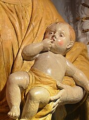 Photographie d'un détail de la statue de Notre Dame de la Gorge, l'enfant Jésus suçant son index droit.