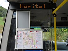 Photographie en couleurs d’un écran lumineux et d'un plan du réseau avec des informations à bord d’un minibus.