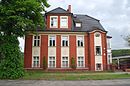 Mehrfamilienhaus mit Hofgebäude und straßenseitiger Einfriedung