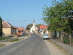 Az út Nemescsó főutcájaként, nyugat felől, a falu evangélikus templomával