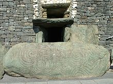 The sunlight enters the tomb at Newgrange via the roofbox built above the door. Newgrange Eingang Stein.jpg