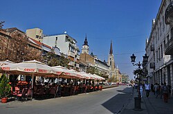 Palác Klajn vyčnívající na levé straně zpoza restauračních zahrádek