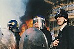 A Metropolitan Police officer wearing the custodian helmet 'public order' chin strap during Poll Tax Riots, 1990