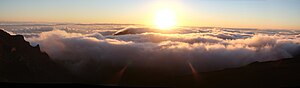 The sun rises from the clouds over Maui, taken...