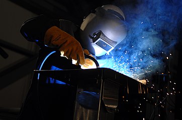 Robert Bowker welds the initials of Susan Ford Bales into the keel of the aircraft carrier Gerald R. Ford (CVN 78) during a keel laying and authentication ceremony