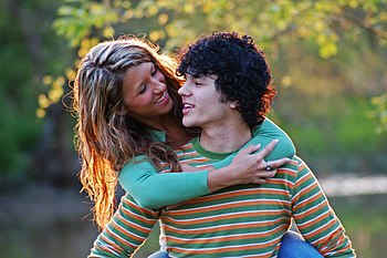 English: A young woman and man embracing while...