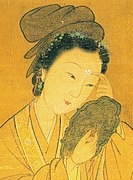 Woman applying huadian in the shape of a flower