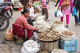A woman selling shallots (far–right) in Kathmandu, Nepal