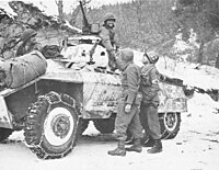 M8 armored car on patrol from U.S. 11th Armored Division, U.S. Third Army links up with soldiers of the U.S. 84th Infantry Division of U.S. First Army west of Houffalize, Belgium. January 16, 1945.