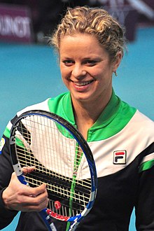 Close-up portrait of Clijsters smiling with her tennis racket