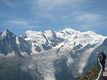 Photographie en couleurs de massifs montagneux enneigés.