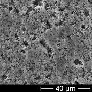 SEM image of the rough anode surface of an unused electrolytic capacitor, showing the openings of pores in the anode