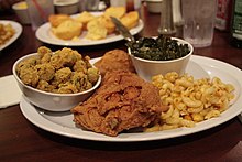 A traditional soul food dinner consisting of fried chicken with macaroni and cheese, collard greens, breaded fried okra and cornbread Soul Food at Powell's Place.jpg