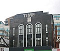 The Time Building on Station Road with a Miller-branded clock - formerly home of Time nightclub in 2000; today part converted into residential use[100]