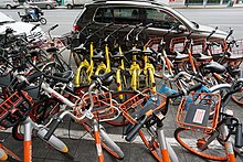 Bicycle-sharing systems, such as ofo (yellow) and Mobike (orange), are common in Shanghai. Various bike-share bikes in china.jpg