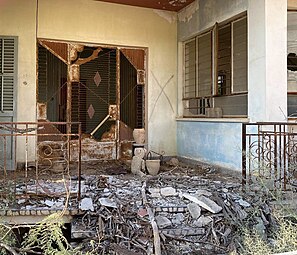 An abandoned house in Varosha; in front of the home is a frayed teddy bear.