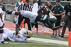 A player diving with his back to the ground as he crosses into the end zone