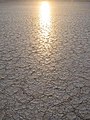 Puesta de sol reflejada en el lago seco.