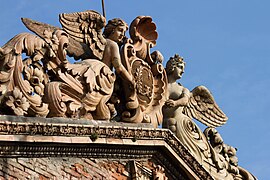 Fronton côté cour, deux anges tenant un blason avec un "G"