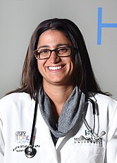 Mona Hanna-Attisha led the first Hurley Medical Center lead poisoning study. Dr. Hanna Attisha smiling in lab coat.jpg