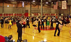 Intermediate level international style latin dancing at the 2006 MIT ballroom dance competition.  A judge stands in the foreground.