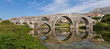 Photographie du pont Arslanagić, se reflétant sur la Trebišnjica.