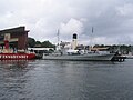 HSwMS Spica moored outside of the Vasa Museum in July 2005. The tall funnel belongs to SS Sankt Erik, moored on the other side of the jetty.