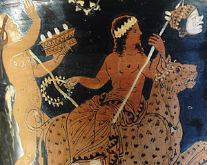 Bůh Dionýsos sedí na levhartím hřbetu, v ruce má kopí s lidskou hlavou, za ním jde Papposilénos s tamburínou – zobrazení na antické váze