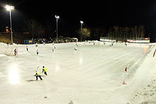 The skaters in yellow vests in the foreground are ball boys at this bandy game. Hanninhauta 2014.JPG