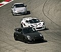 Чорний Porsche 997 GT2, сірий 997 GT3 RS і білий Lotus Exige на трасі під час гонок у 2011 році