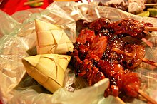 Filipino puso rice cakes, made from glutinous rice cooked in woven pouches of various designs, are eaten with savory dishes Puso and BBQ Feast - Chicken Skin, Pork Belly, Chicken Liver and Intestines.jpg