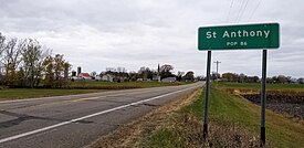 highway sign reading St. Anthony population 86 with the small town in the distance