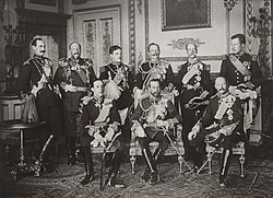 The Nine Sovereigns at Windsor for the funeral of King Edward VII, photographed on 20 May 1910. Standing, from left to right: King Haakon VII of Norway, Tsar (King) Ferdinand of the Bulgarians, King Manuel II of Portugal and the Algarve, Kaiser (Emperor) Wilhelm II of Germany, King George I of the Hellenes and King Albert I of the Belgians. Seated, from left to right: King Alfonso XIII of Spain, King George V of the United Kingdom and King Frederik VIII of Denmark. The Nine Sovereigns at Windsor for the funeral of King Edward VII.jpg