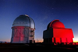 The towering Víctor M. Blanco 4-meter Telescope and one of the four SMARTS Consortium telescopes, both set against the spectacular backdrop of the early evening sky