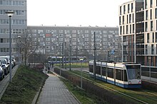 Photographie d'un quartier avec plusieurs bâtiments et une ligne de tramway.