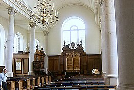 Church interior with stone columns, barrel vault, arched window