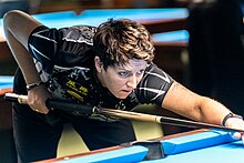 A woman playing pool