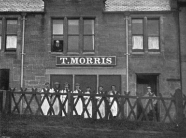 The golf shop of Old Tom Morris in St Andrews, Scotland, c. 1890. Morris is looking out the second storey window (upper left).