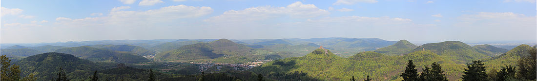 panorama rigardo (direkto nordokcidento ĝi nordoriento) de la Rehbergturm al la centra kaj orienta Palatinata Arbaro : Malfone la Trifels (meze de la bildo)