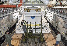 Test article being airlifted to the Pad Abort-1 flight test Technicians carefully position an Orion flight test crew module.jpg