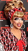 Photograph of a drag performer wearing a blue wig