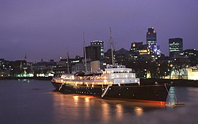 Photo nocturne d'un navire de croisière illuminé sur un fleuve