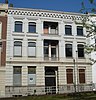 Herenhuis met gepleisterde lijstgevel. Middenpartij met loggia's, stucversieringen en kroonlijst op uitgekraagd boogfries