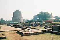 Arkeologinen, buddhalaisen luostarin jäämistö puistosta Sarnathissa; tässä puistossa Gautama Buddha opetti dharmaa ensimmäisen kerran. Suuri pyöreä rakennus takavasemmalla on Dhamek stupa, takaoikealla jainalaisten temppeli.