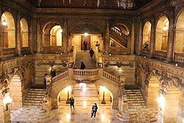 Photograph of the main lobby showing two staircases leading up to landing and a single staircase leading up to the second floor