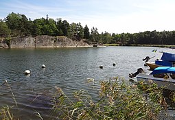 Fritidsbåtar vid västra stranden och berget på östra sidan.